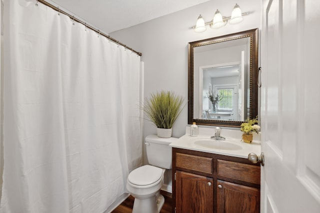 bathroom featuring a shower with shower curtain, toilet, hardwood / wood-style flooring, and vanity