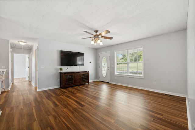 unfurnished living room with a textured ceiling, ceiling fan, and dark hardwood / wood-style floors