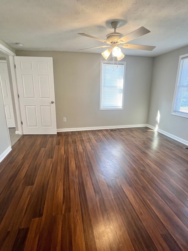 spare room with ceiling fan, plenty of natural light, and dark hardwood / wood-style flooring