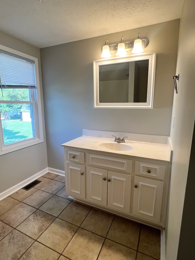 bathroom featuring vanity, a textured ceiling, and tile patterned floors