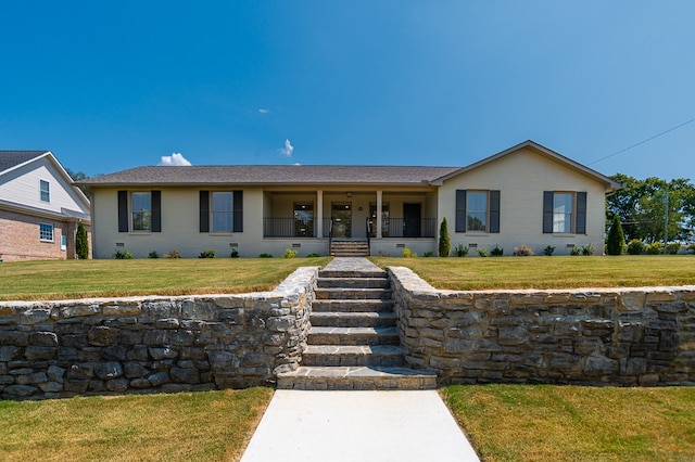 ranch-style house featuring a porch and a front yard