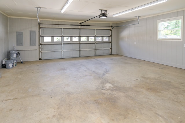 garage featuring electric panel, wood walls, and a garage door opener