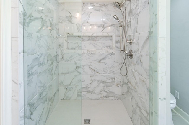bathroom featuring a marble finish shower and toilet