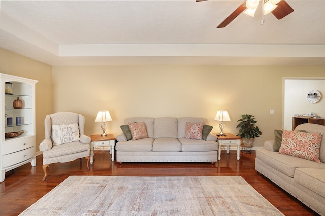 living room featuring dark wood-type flooring and ceiling fan