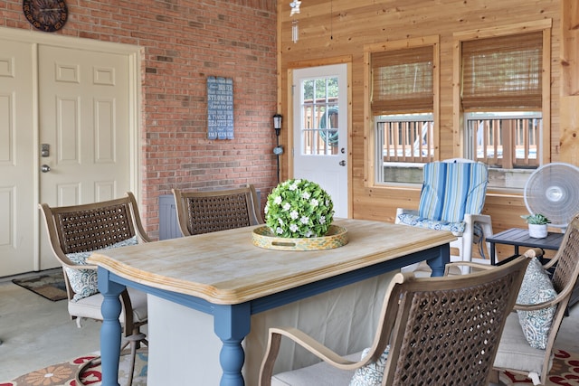 dining room featuring concrete floors and wood walls