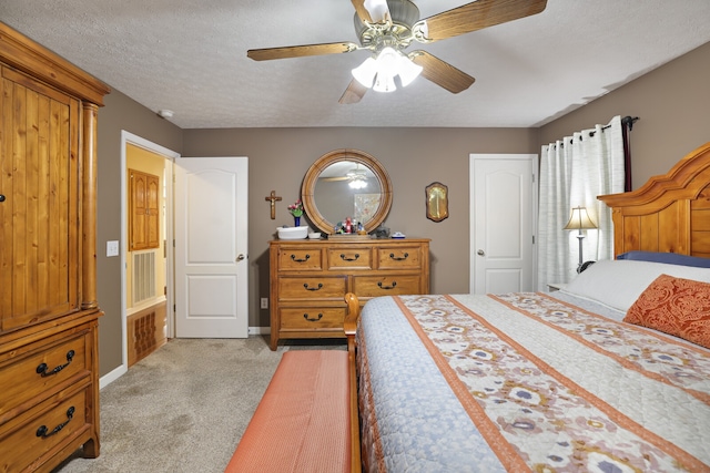 carpeted bedroom featuring a textured ceiling and ceiling fan