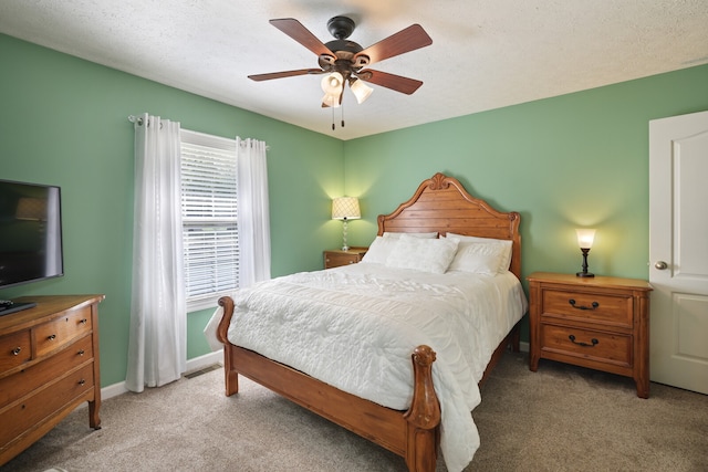 bedroom with a textured ceiling, carpet flooring, and ceiling fan