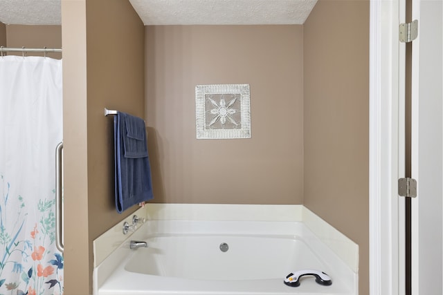 bathroom with a textured ceiling and separate shower and tub