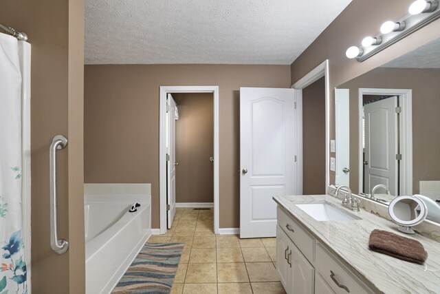 bathroom featuring vanity, a bath, tile patterned floors, and a textured ceiling