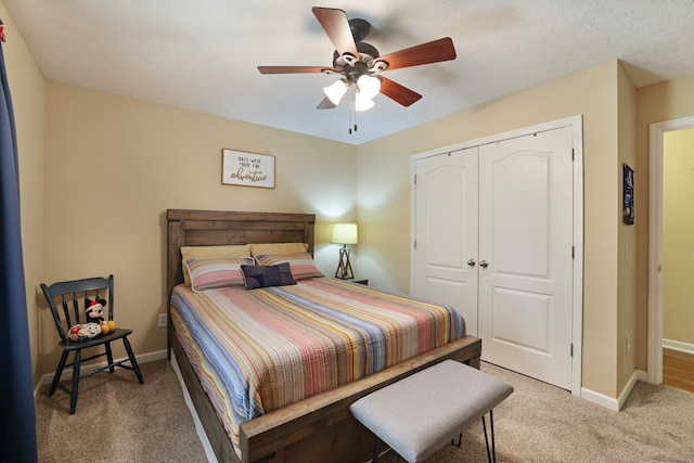 bedroom with a closet, a textured ceiling, ceiling fan, and carpet floors