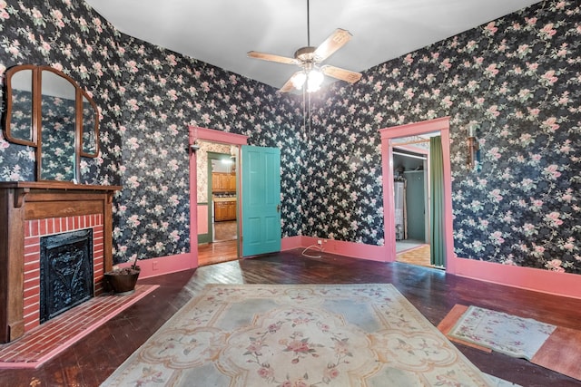 interior space with wood finished floors, a fireplace, baseboards, and wallpapered walls