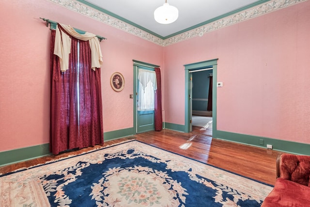 foyer featuring crown molding, baseboards, and wood finished floors