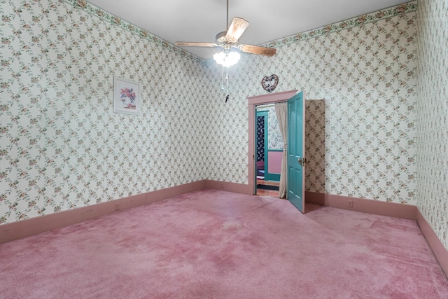 empty room with carpet, ceiling fan, baseboards, and wallpapered walls