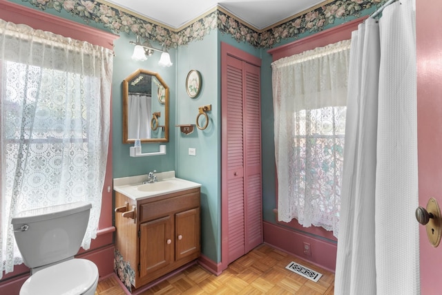 bathroom featuring toilet, a closet, vanity, and visible vents