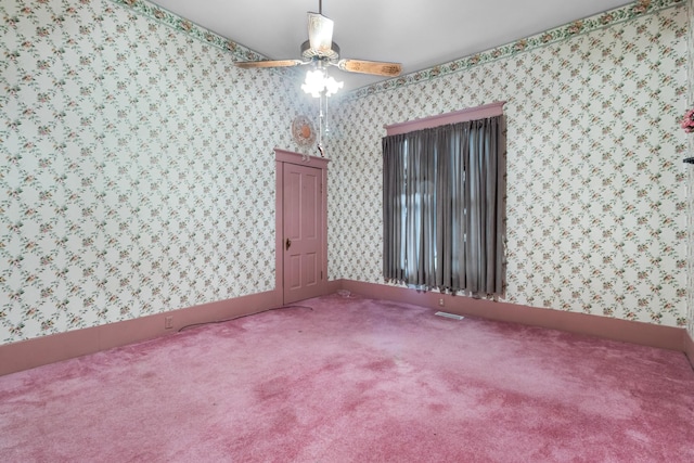 empty room with ceiling fan, carpet flooring, visible vents, baseboards, and wallpapered walls