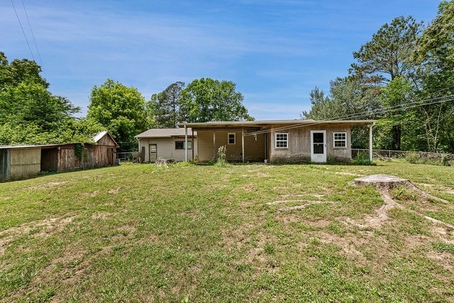 rear view of house featuring a yard