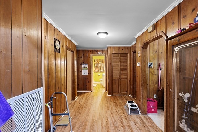 mudroom featuring wooden walls, light hardwood / wood-style floors, and crown molding