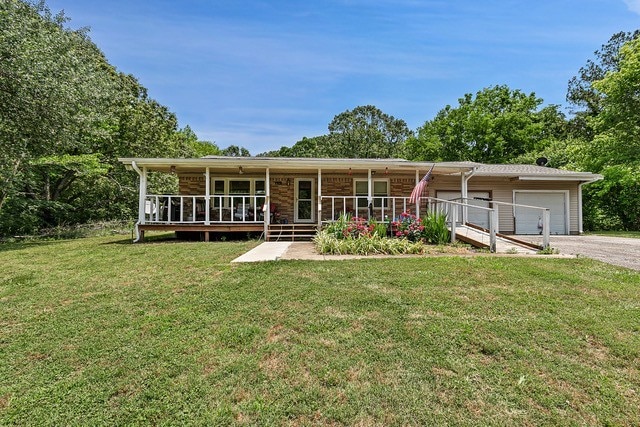 view of front of home featuring a front lawn, a garage, and covered porch