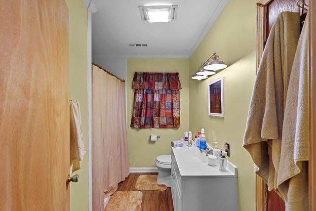 bathroom featuring vanity, wood-type flooring, toilet, ornamental molding, and a shower with curtain