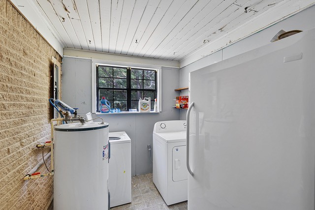 clothes washing area with washing machine and clothes dryer, gas water heater, and wooden ceiling