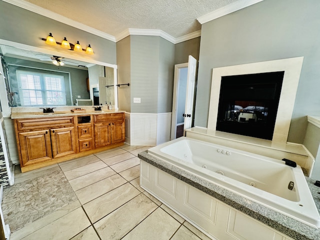 bathroom with ceiling fan, vanity, a tub, a textured ceiling, and crown molding