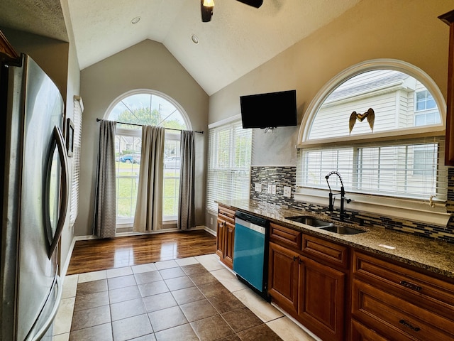 kitchen with light wood-type flooring, sink, stainless steel appliances, and plenty of natural light