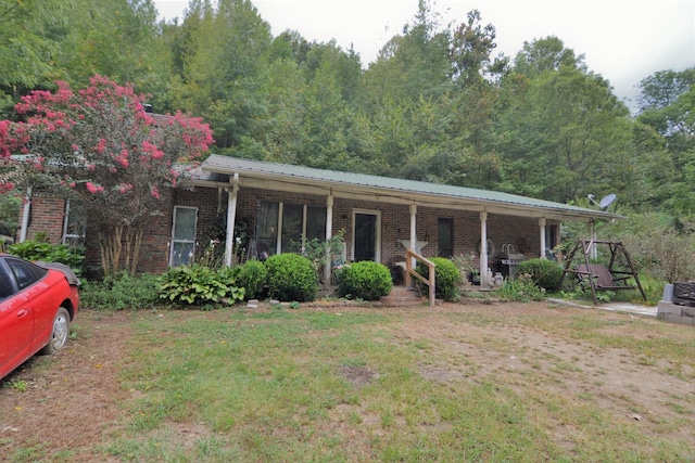 555 Myrick Branch Rd, Pulaski, TN 38478 - ranch-style house with a porch, brick siding, a front lawn, and metal roof