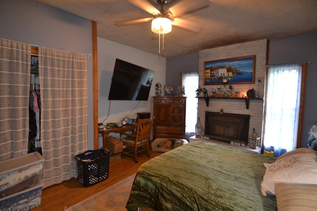 555 Myrick Branch Rd, Pulaski, TN 38478 - bedroom featuring wood finished floors, a brick fireplace, multiple windows, and ceiling fan