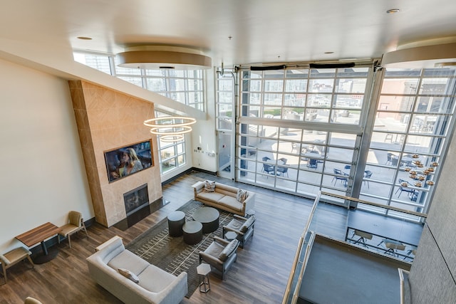 living room with dark hardwood / wood-style floors, a wall of windows, and a tile fireplace