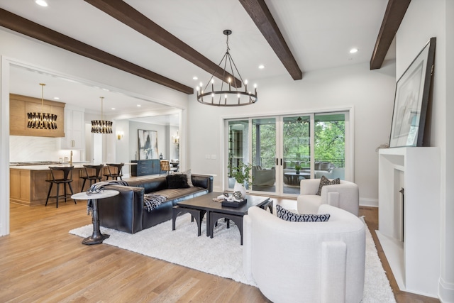 living room featuring a fireplace, an inviting chandelier, light hardwood / wood-style floors, and beamed ceiling