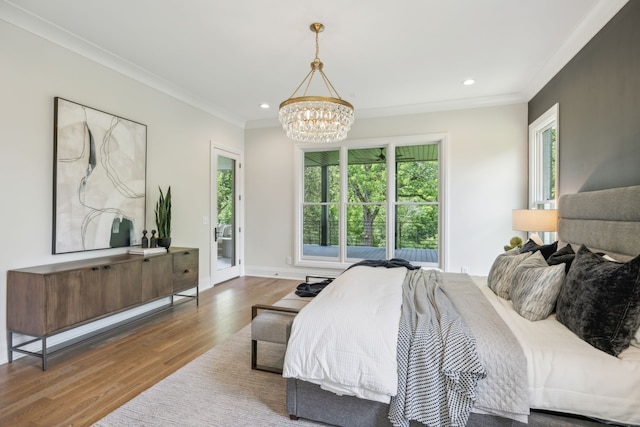 bedroom with crown molding, hardwood / wood-style flooring, access to exterior, and a notable chandelier