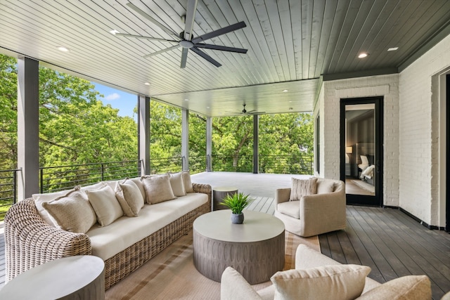 sunroom featuring a fireplace, wood ceiling, and ceiling fan