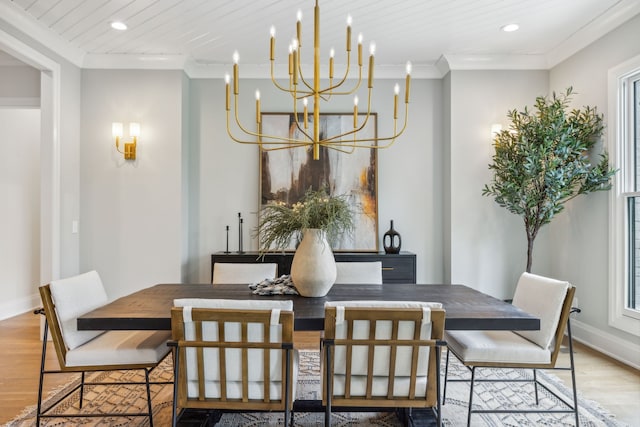 dining space featuring ornamental molding, light hardwood / wood-style flooring, an inviting chandelier, and a healthy amount of sunlight