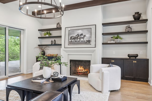 living room featuring light hardwood / wood-style floors, a chandelier, and beam ceiling