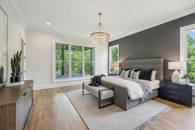 bedroom with light hardwood / wood-style flooring, ornamental molding, and a notable chandelier