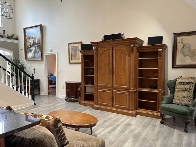 living room featuring a high ceiling and light hardwood / wood-style floors