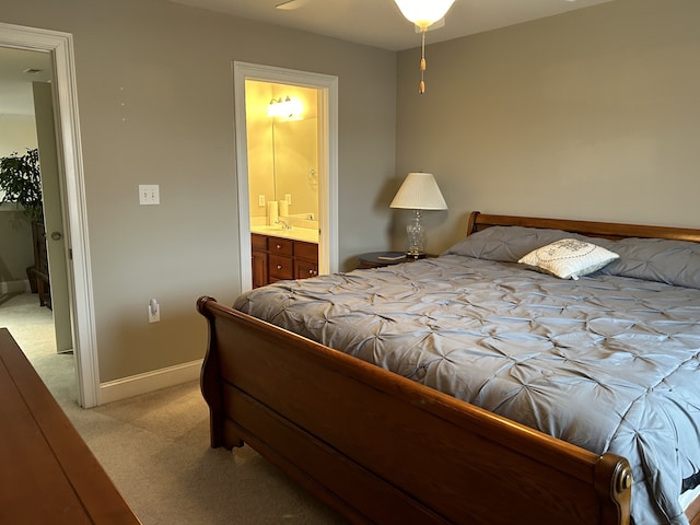 carpeted bedroom with ceiling fan, connected bathroom, and sink