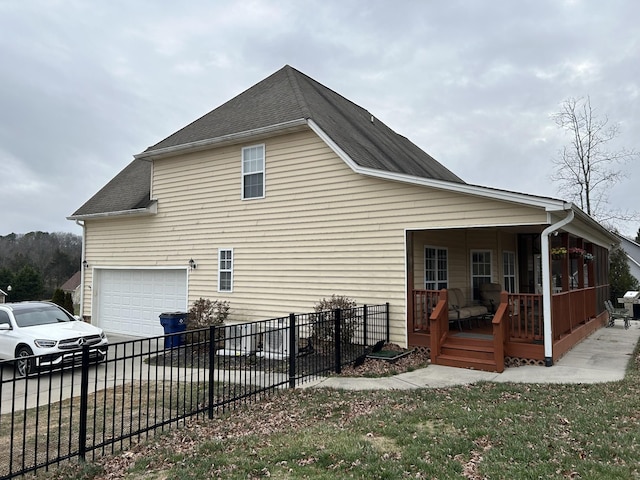 view of side of property featuring driveway, fence, an attached garage, a shingled roof, and a porch