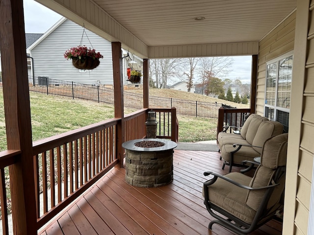 deck with an outdoor fire pit, a yard, and a fenced backyard