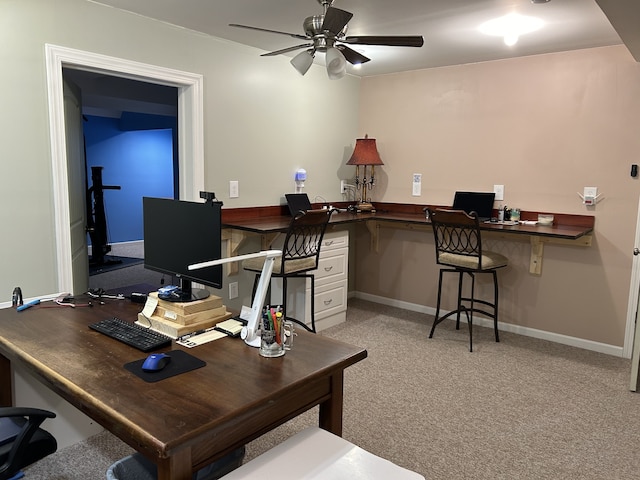 office area with light colored carpet, ceiling fan, and built in desk