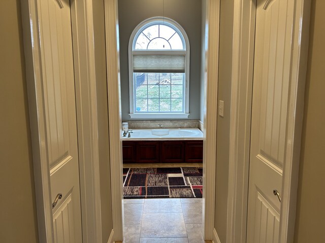 bathroom featuring a bath and tile patterned flooring