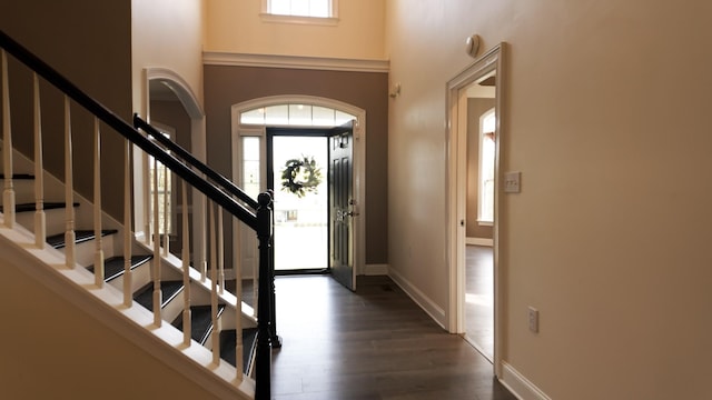 entryway with baseboards, stairway, a high ceiling, and wood finished floors