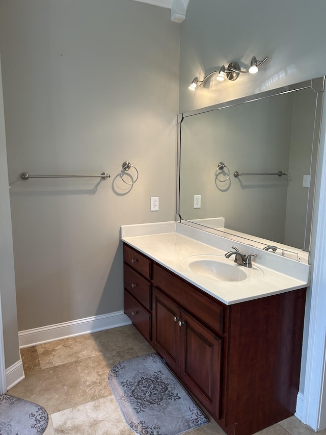 bathroom featuring baseboards, vanity, and stone finish floor