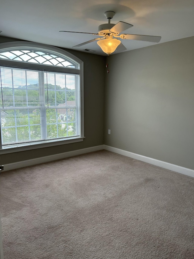 spare room featuring ceiling fan, carpet, baseboards, and visible vents
