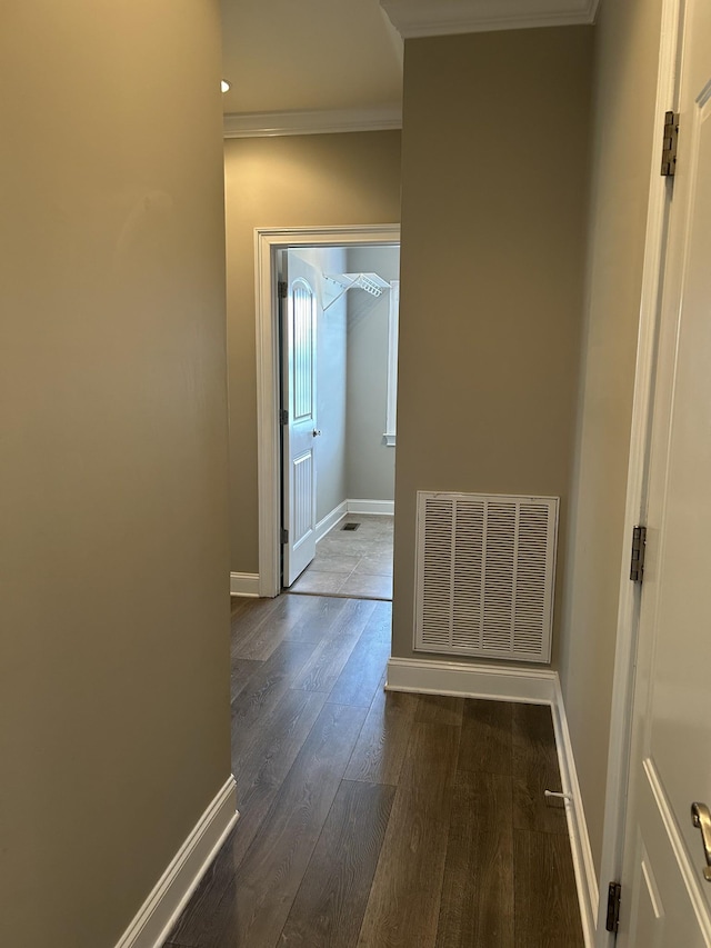 hall featuring crown molding, visible vents, wood finished floors, and baseboards