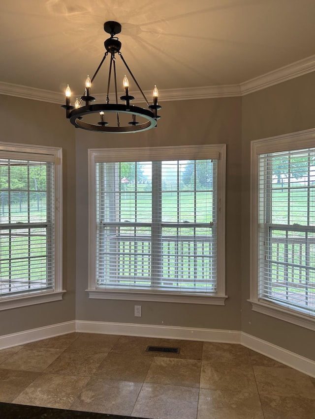 unfurnished dining area with plenty of natural light, a chandelier, baseboards, and visible vents