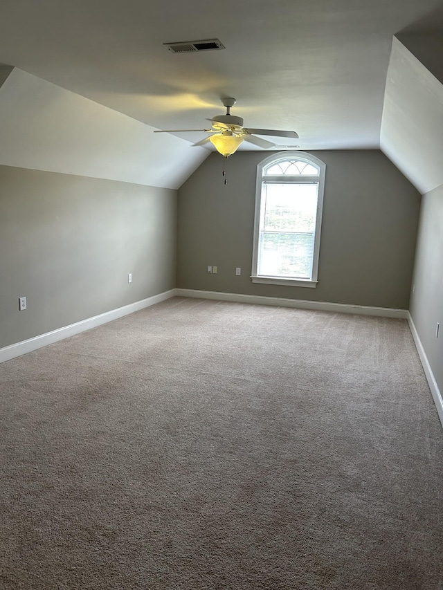 additional living space featuring vaulted ceiling, ceiling fan, baseboards, and visible vents