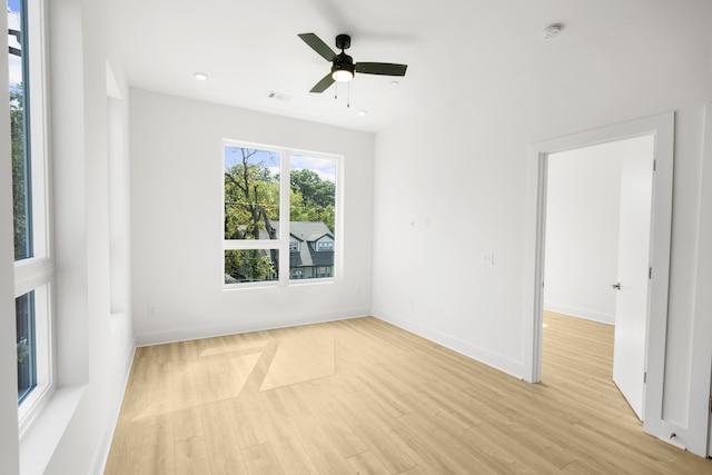 empty room with ceiling fan and light hardwood / wood-style floors