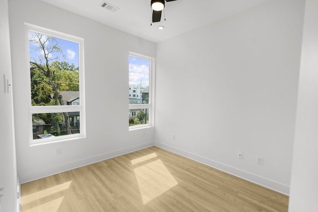 unfurnished room featuring light wood-type flooring, ceiling fan, and a wealth of natural light