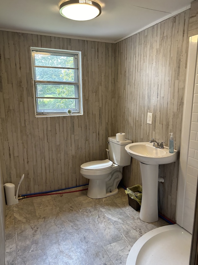 bathroom featuring toilet and wood walls